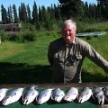 A man standing next to a table with fish on it.