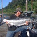 A man holding a large fish on top of a boat.