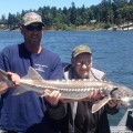 Two people holding a fish on the water.