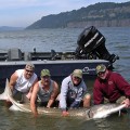 A group of men in the water with a fish.