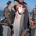 A man holding a fish on top of a boat.