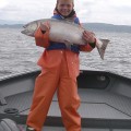 A person holding a fish on top of a boat.