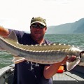 A man holding a fish on top of a boat.