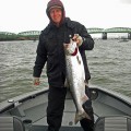 A man holding a fish on top of a boat.