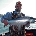 A man holding a fish on top of a boat.