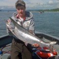 A man holding a large fish on top of a boat.