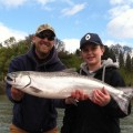 A man and boy holding up a fish.