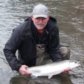 A man holding a fish in the water.