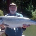 A man holding a large fish on top of a dock.