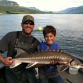 A man and boy holding up a fish.