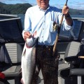 A man holding a fish on top of a boat.