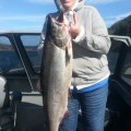 A woman holding a large fish in her hand.