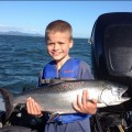 A young boy holding a fish in his hands.