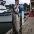 A man holding a large fish on the dock.