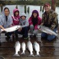 A family with six fish on the dock.