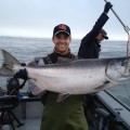 A man holding a large fish on top of a boat.