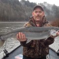 A man holding a fish on top of a boat.