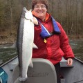 A woman holding a fish on top of a boat.