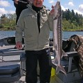 A man holding a fish on top of a boat.