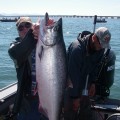 A group of people holding up a large fish.