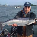 A man holding a large fish on top of a boat.