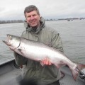 A man holding a large fish on top of a boat.