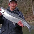 A man holding a fish in his hand.