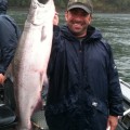 A man holding a large fish on top of a boat.