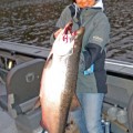 A man holding a large fish on top of a boat.