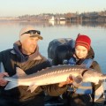 A man and boy holding up a fish.