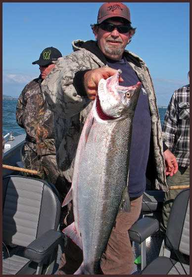 A man holding a large fish on top of a boat.