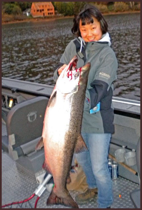 A man holding a large fish on top of a boat.