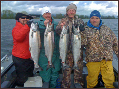 Four men holding up fish on a boat.