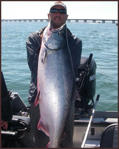 A man holding a large fish on top of a boat.